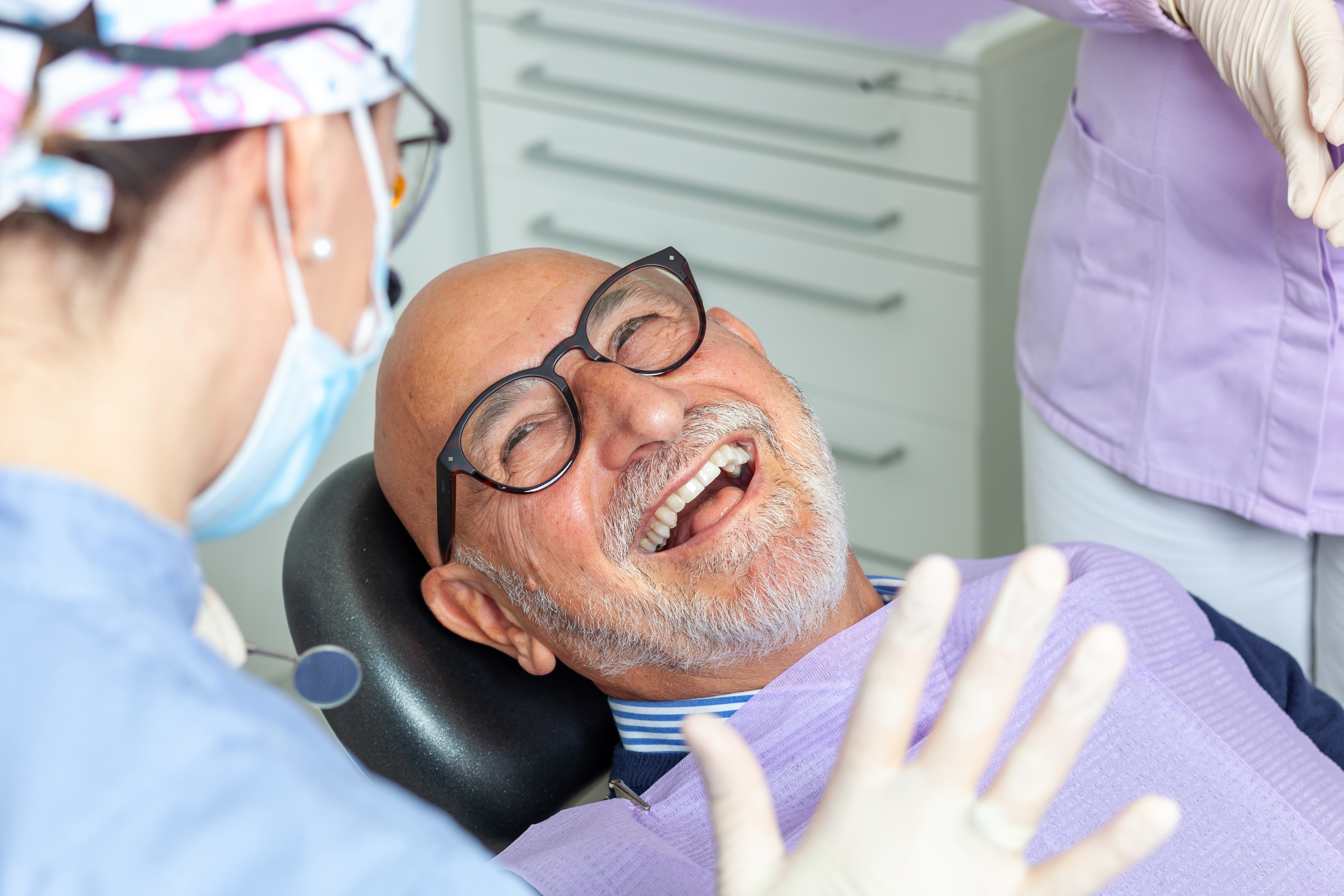 An elderly man smiling in the dental chair.