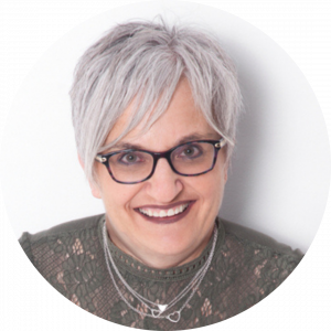 Headshot image of Assistant Professor Melanie Hamilton. She has short silver hair, and is smiling is this photo.