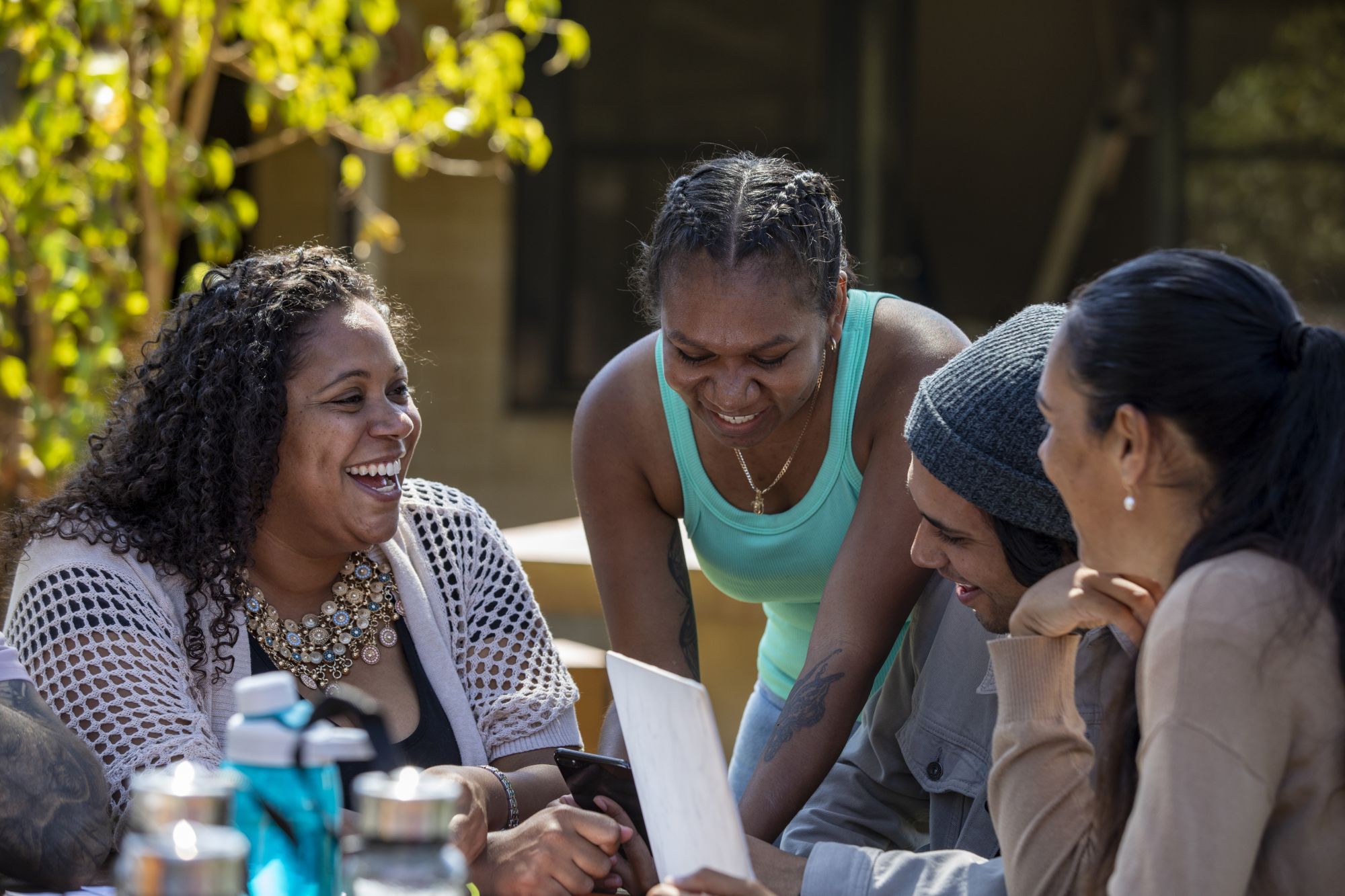 Indigenous women talking and smiling around a table