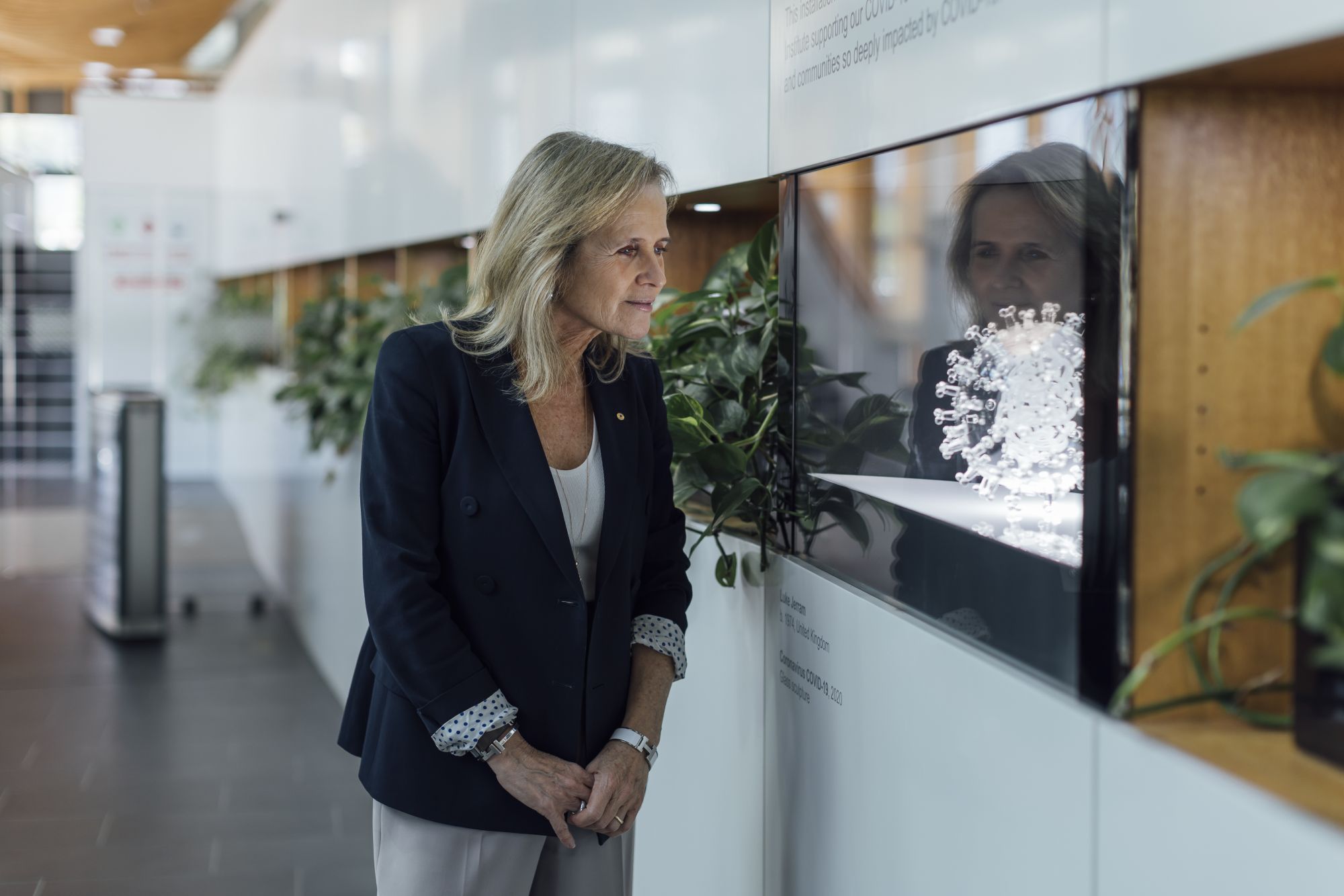 Professor Sharon Lewin AO, Director of the Doherty Institute observes a sculpture of the COVID-19 virus