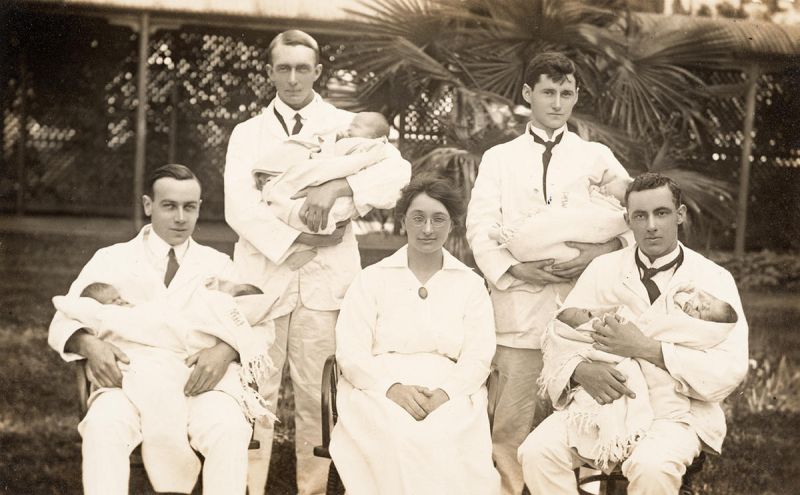 Dr Hilda Kershaw (MBBS 1917) sits in the middle of for young male medical students, each of them holding a baby, at the Womens Hospital 1918.