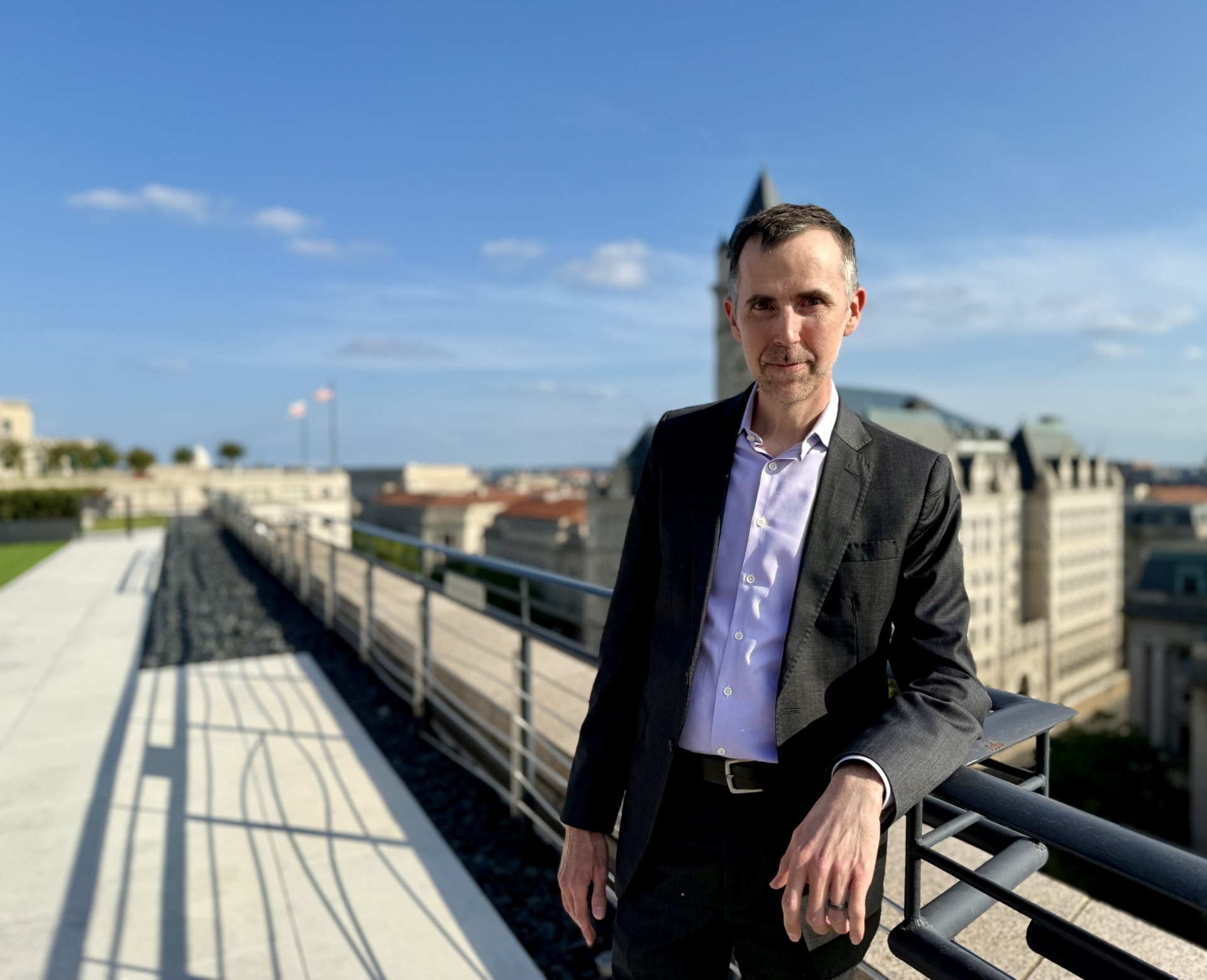 Professor Rob Saunders, pictured wearing a suit and leaning against a railing.