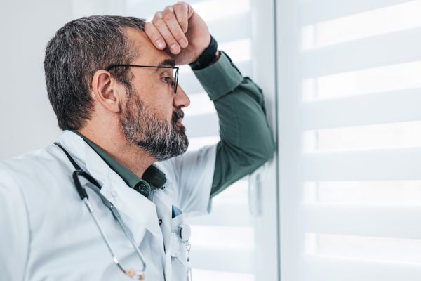 Exhausted man looking through the window
