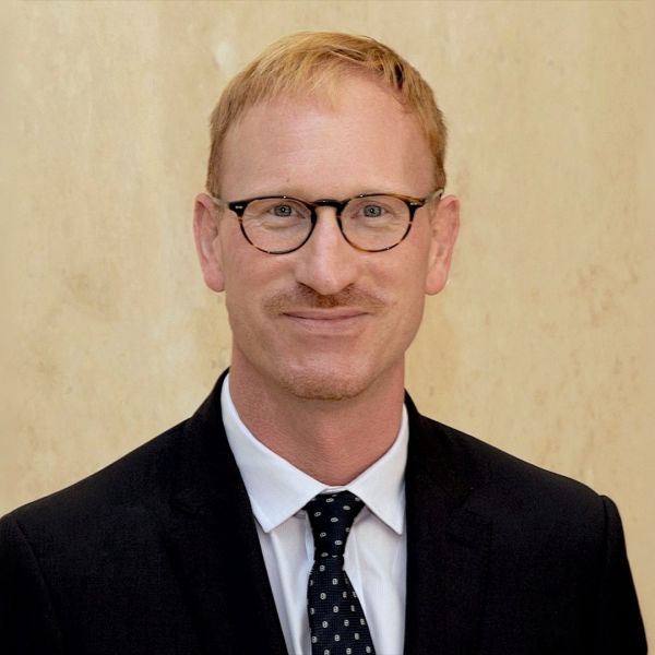 Professor Peter Steel wearing a suit and tie with a plain background.
