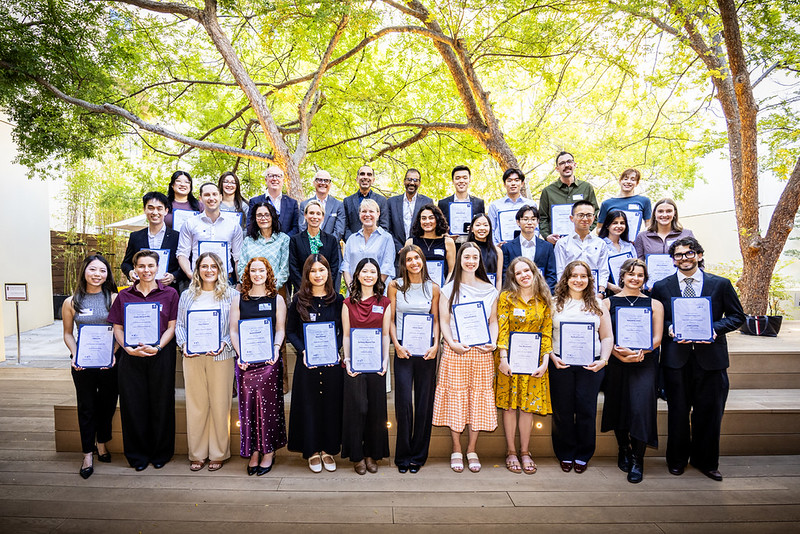 A photo of a large group of individuals, about 30, holding certificates.